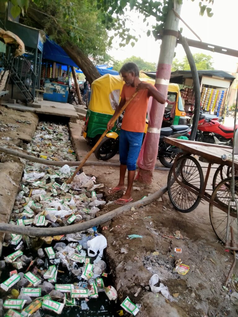 सिकंदराबाद: नगर पालिका सिकंदराबाद द्वारा चलाए जा रहे विशेष सफाई अभियान के दौरान रोडवेज बस स्टैंड क्षेत्र की नालियों की सफाई करते समय चौंकाने वाली तस्वीरें सामने आई हैं। सफाई कर्मचारियों ने नालियों से बड़ी मात्रा में देसी शराब के खाली टेट्रा पैक (रेफर) और अन्य कचरे को बाहर निकाला, जो नालियों के जाम होने का मुख्य कारण बन रहे थे।

स्थानीय लोगों और सफाईकर्मियों की मानें तो यह आम दृश्य बन चुका है कि बस स्टैंड के पास देसी शराब की दुकानों से शराब खरीद कर लोग बाहर खड़ी ठेलियों पर शराब पीते हैं और फिर खाली पैक वहीं नाली में फेंक देते हैं। इससे नालियां लगातार जाम हो रही हैं और गंदगी फैल रही है।

नालियों में फेंके गए शराब के पैक, पॉलिथीन और अन्य कचरे की वजह से नालियां चोक हो जाती हैं, जिससे मच्छरों का प्रकोप बढ़ रहा है और दुर्गंध फैल रही है। ऐसे हालात डेंगू, मलेरिया जैसी बीमारियों के फैलने का खतरा पैदा कर रहे हैं।

नगर पालिका की टीम ने सफाई अभियान के तहत सफाई कर्मचारियों के साथ मिलकर नालियों की गंदगी को बाहर निकाला और चेतावनी दी कि सार्वजनिक स्थानों को गंदा करने वालों के खिलाफ जल्द ही कार्रवाई की जाएगी।

स्थानीय निवासियों ने नगर प्रशासन से अपील की है कि शराब पीने वालों पर सख्ती बरती जाए और सार्वजनिक स्थानों पर निगरानी के लिए सीसीटीवी कैमरे लगाए जाएं ताकि इस तरह की गंदगी पर रोक लगाई जा सके।
